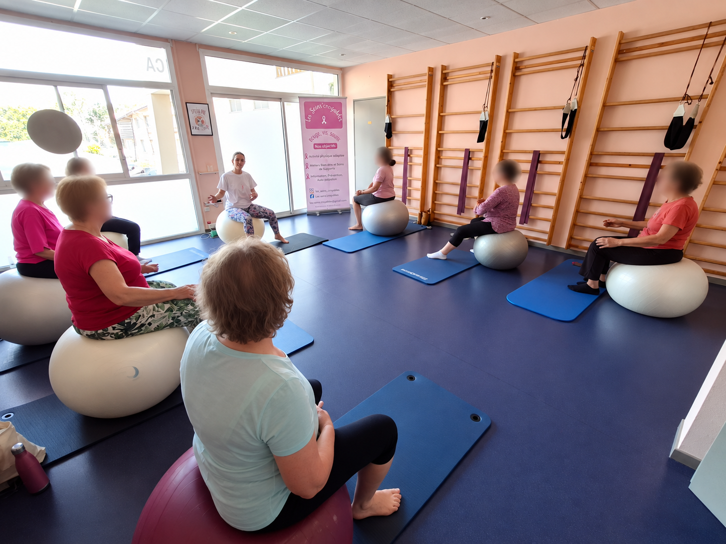 Participantes assises sur de grands ballons pendant l'atelier gym ballon