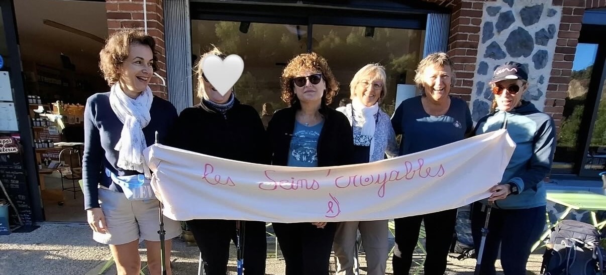 Les six marcheuses des Seins’Croyables avec leur banderole devant le gîte, sur le chemin de Compostelle