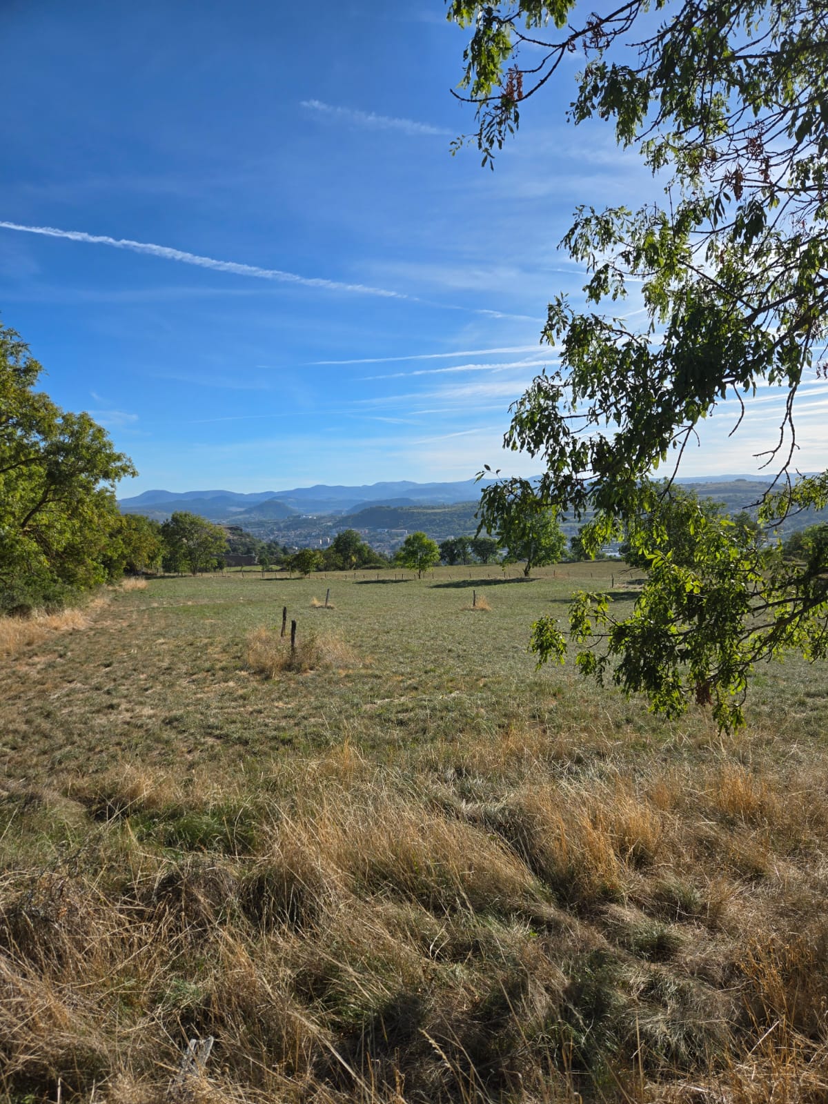Paysage ouvert sur la campagne et les monts au fil de la marche