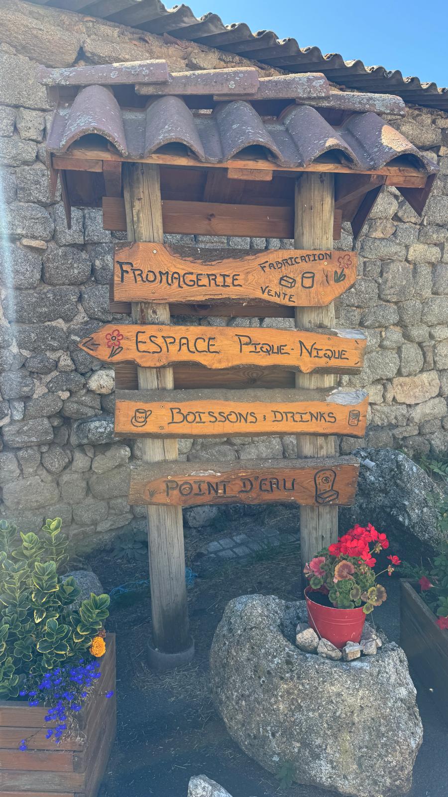 Panneaux en bois indiquant la fromagerie et l’espace pique-nique