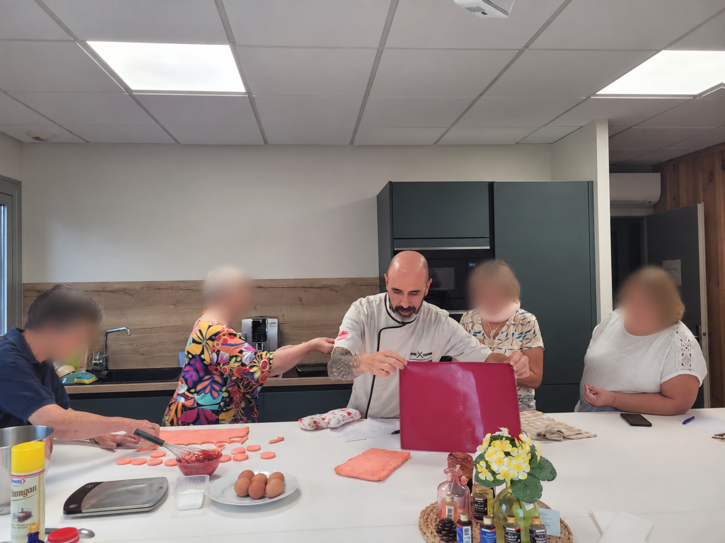 Cyril et les participantes autour du plan de travail, visages des participantes floutés