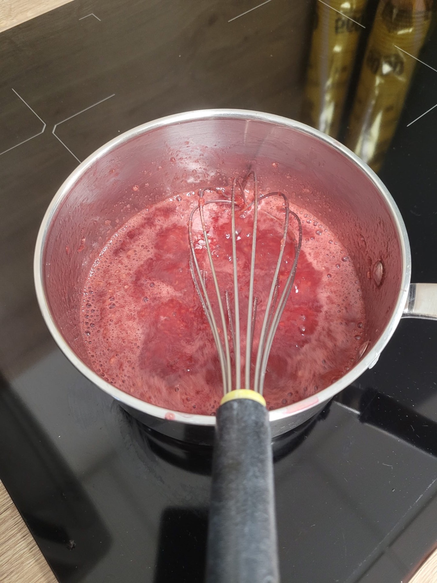 Préparation rose dans une casserole avec un fouet